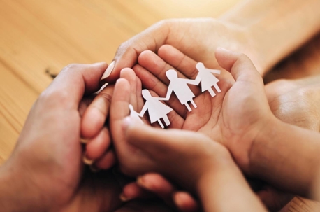 Hands holding family figurines, symbolizing unity and support