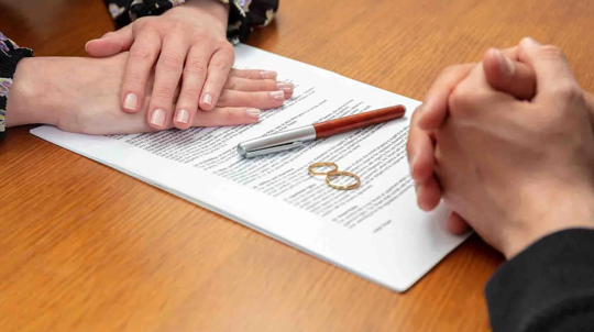 Former couple with uncontested divorce papers and wedding rings