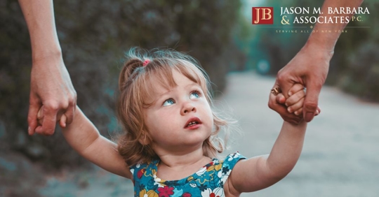 small child holding both hands with parents