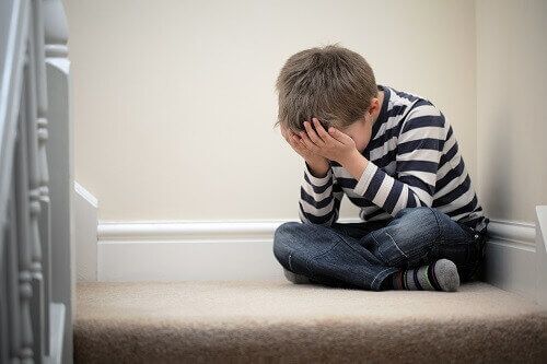 Neglected child crying on stairs